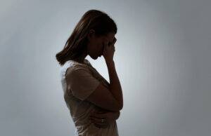Porträt einer depressiven Frau, die ihr Gesicht verdeckt